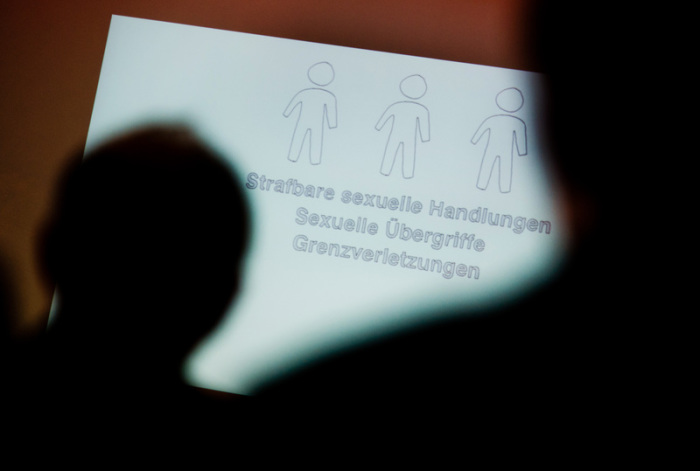 Tagungsteilnehmer betrachten bei einer Fachtagung zur Prävention von sexuellem Missbrauch eine Präsentation. Foto: Julian Stratenschulte/Dpa