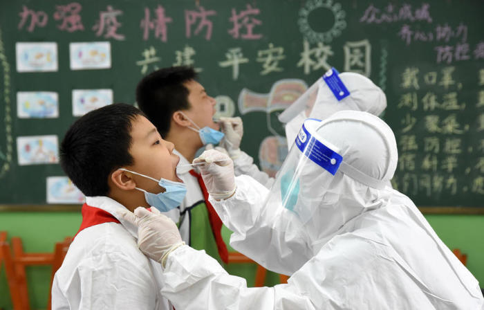 Mitarbeiter des Gesundheitswesens nehmen Abstrichproben bei Schülern einer Grundschule in Handan, Provinz Hebei. Foto: epa/Hao Qy