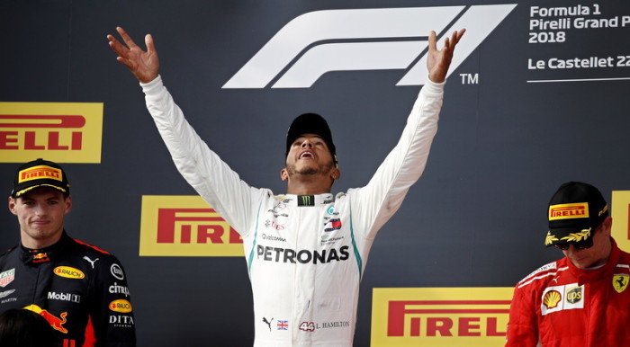 Der britische Formel-1-Pilot Lewis Hamilton (M.) von Mercedes AMG GP feiert auf dem Podium. Foto: epa/Yoan Valat