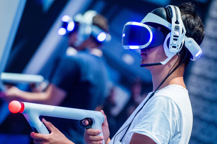 Ein Besucher der Gamescom 2018 probiert an einem Stand ein Videospiel mit einer VR-Brille aus. Foto: Christophe Gateau/Dpa