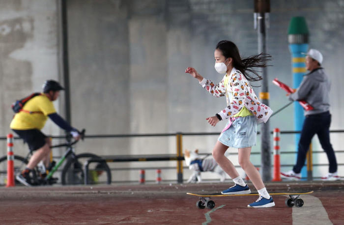 Ein Kind, das eine schützende Gesichtsmaske trägt, fährt im Yeouido Hangangang Park in Seoul, Südkorea, auf einem Skateboard. Foto: epa/YONHAP