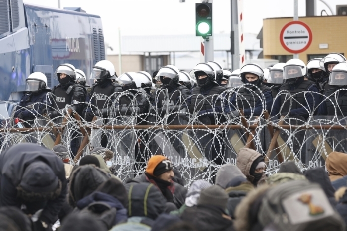 Das von der belarussischen Staatsagentur BelTA via AP zur Verfügung gestellte Handout zeigt Migranten, die sich vor einem Stacheldrahtzaun am Kontrollpunkt Kuznica an der belarussisch-polnischen Grenze versammeln. Foto: Oksana Manchuk