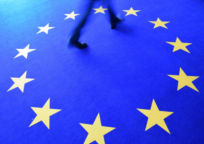 Ein Mensch läuft während der Europawahl in Berlin auf einem Teppich mit einem Europa-Logo. Foto: epa/Clemens Bilan