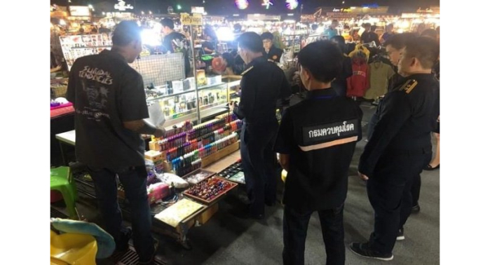 Fahnder konfiszieren an einem Marktstand E-Zigaretten, deren Verkauf in Thailand verboten ist. Foto: The Nation
