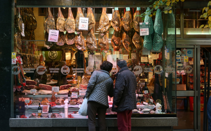 «Jamon» (iberischer Schinken) und andere Fleischsorten werden bei einem Fleischer im spanischen Madrid in der Auslage seines Geschäftes angeboten. Foto: Friso Gentsch/Dpa