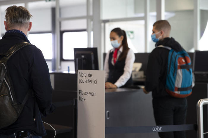 Passagiere mit Gesichtsmasken beim Check-in auf den Swiss International Air Lines. Foto: epa/Salvatore Di Nolfi