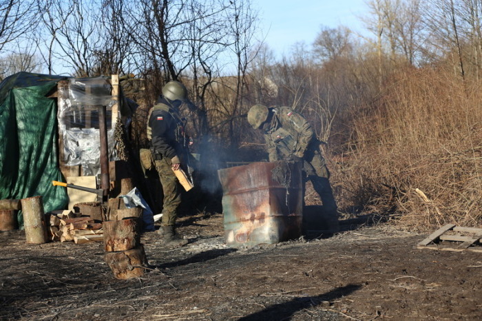 Polnische Soldaten wärmen sich an einem Feuer vor ihrem Unterstand in Usnarz Gorny an der Grenze zu Belarus. Foto: Doris Heimann/dpa