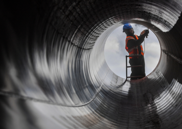 Ein Arbeiter schleift an einem Rohr auf der Baustelle der europäischen Gas-Anbindungsleitung (EUGAL). Foto: Patrick Pleul/Zb/dpa
