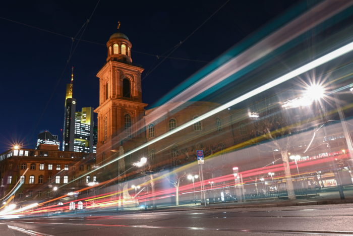 Autolichter und eine Straßenbahn erzeugen bei Anbruch der Dunkelheit Lichtspuren vor der Frankfurter Paulskirche. Foto: Arne Dedert/Dpa