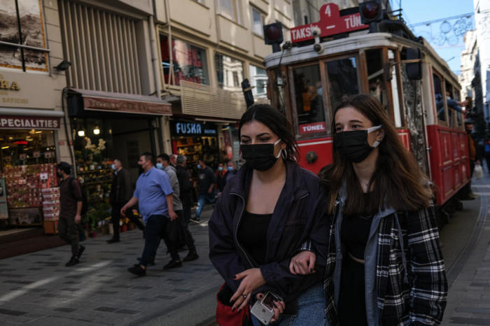 Leute tragen Gesichtsmasken, während sie ihre Zeit an einem sonnigen Tag auf der Istiklal Straße in Istanbul genießen. Foto: epa/Sedat Suna