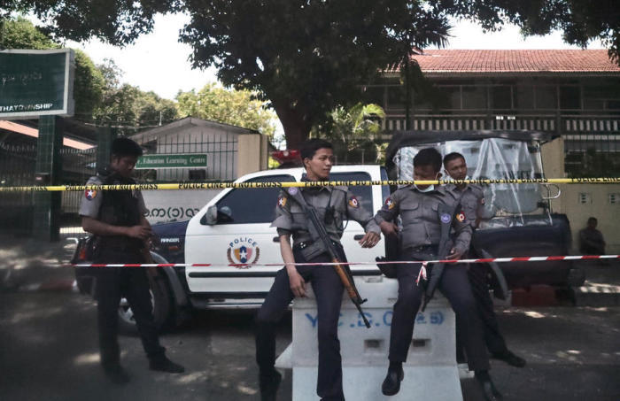 Polizei-Beamte stehen Wache vor einer High School in Yangon. Foto: epa/Stringer