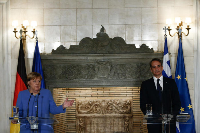 Bundeskanzlerin Angela Merkel (L) spricht neben dem griechischen Premierminister Kyriakos Mitsotakis (R) während einer Pressekonferenz nach ihrem Treffen in Athen. Foto: epa/Yannis Kolesidis