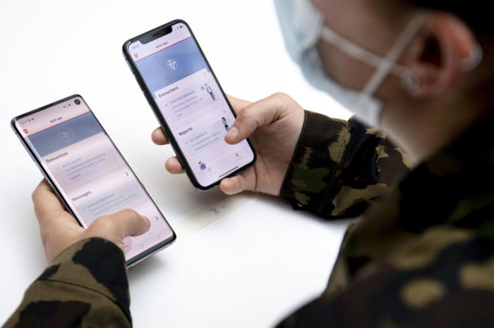 Ein Soldat der Schweizer Armee prüft auf Android- und iOS-Smartphones (Google und Apple) mit Hilfe von Decentralized Privacy-Preserving Proximity Tracing (DP-3T). Foto: epa/Laurent Gillieron