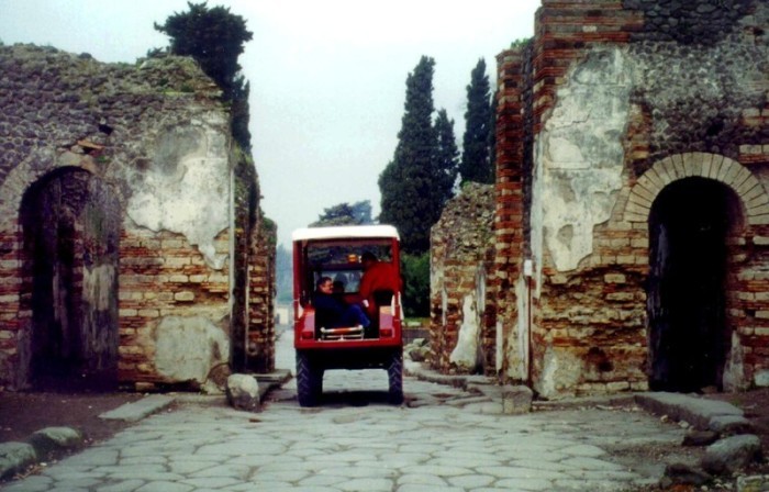 Ein elektrischer Krankenwagen, der von den Kuratoren der archäologischen Stätte von Pompei in einen antiken römischen Wagen verwandelt wurde, pendelt durch Pompei. Foto: epa/Ciro_fusco