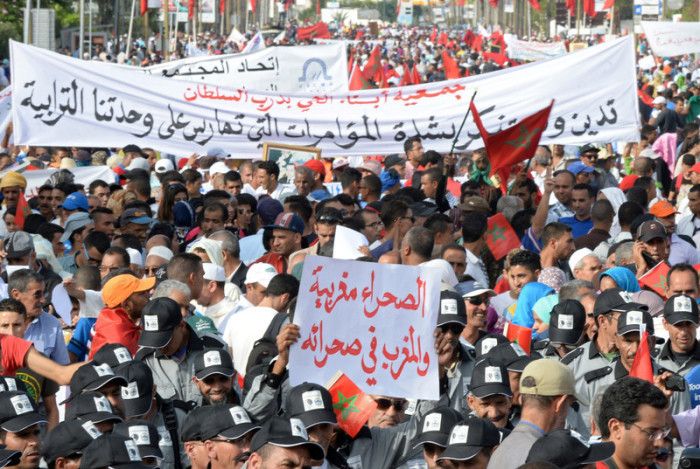 Marokkaner rufen Slogans, während sie mit einem Transparent mit der Aufschrift 
