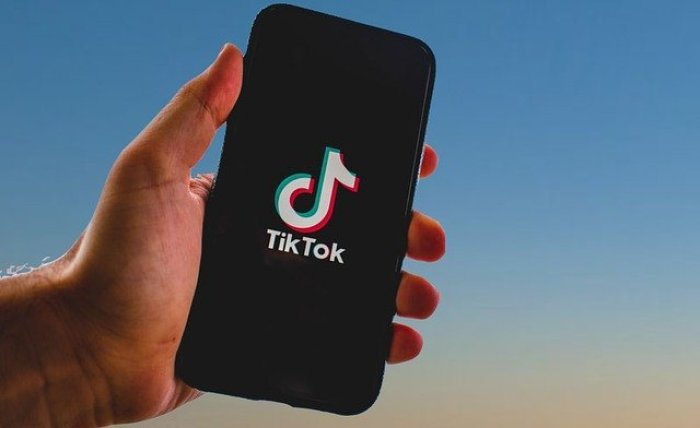 Ein Mädchen hält ihr Smartphone in den Händen, auf dem sie ein Foto der Kurzvideo-App TikTok geöffnet hat. Foto: Jens Kalaene/dpa-zentralbild/dpa