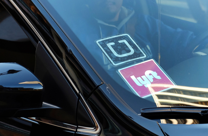 An der Scheibe eines Autos hängen Aufkleber der beiden Fahrdienst-Vermittler «Uber» und «Lyft», aufgenommen am 12.01.2016 in Los Angeles (USA). Foto: Richard Vogel/Ap/dpa