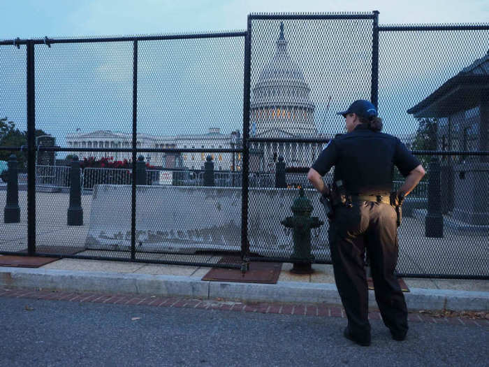 Eine Beamtin der Kapitolpolizei steht vor einem Zaun, der zur Sicherung des US-Kapitols und seines Geländes im Vorfeld einer Pro-Trump-Demonstration errichtet wurde. Gut acht Monate nach der Erstürmung des Kapitols in Washing... Foto: Sue Dorfman