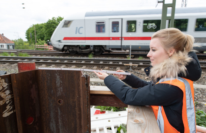Johanna Harten, Bauingenieurin der Deutschen Bahn (DB), steht vor einem neuen Brückenteil mit einem Zollstock in der Hand. Foto: Friso Gentsch/Dpa