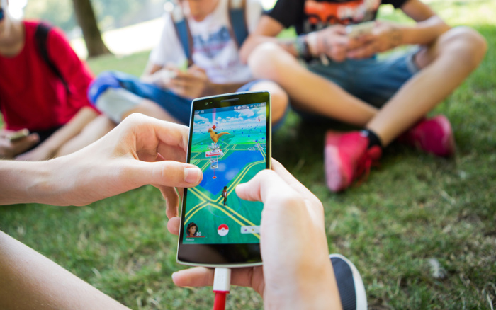 Jugendliche spielen in einem Park das Spiel Pokemon Go auf ihren Smartphones. Foto: Silas Stein/Dpa