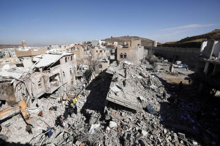 JemenitInnen begutachten die Trümmer von Gebäuden, die von saudi-arabisch geführten Luftangriffen in einem Stadtteil von Sana'a getroffen wurden. Foto: epa/Yahya Arhab
