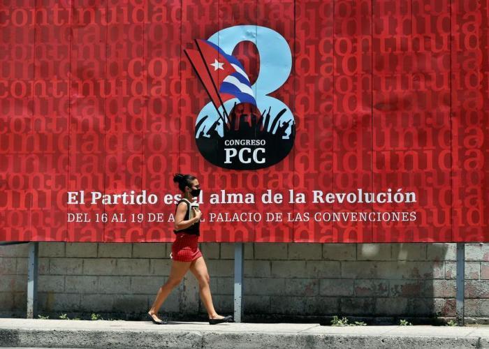 Eine Frau geht vor einem Banner, das für den VIII. Kongress der Kommunistischen Partei Kubas (PCC) wirbt, der vom 16. bis 19. April in Havanna stattfindet. Foto: epa/Ernesto Mastrascusa