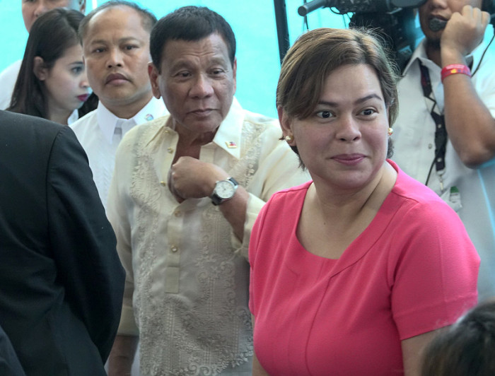 Der philippinische Präsident Rodrigo Duterte (C) wird von der Bürgermeisterin von Davao City, Inday Sara Duterte-Carpio (R), während einer Abflugzeremonie am internationalen Flughafen von Davao City begleitet. Foto: epa/Cerilo Ebrano