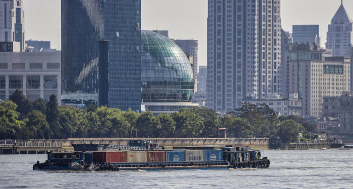 Ein Frachtschiff, beladen mit Containern, fährt auf dem Huangpu-Fluss in Shanghai. Foto: epa/Alex Plavevski