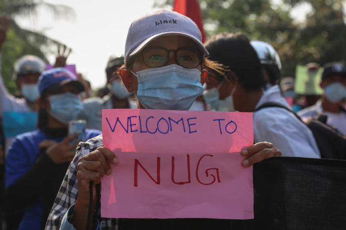 Ein Demonstrant hält ein Banner, das die Unterstützung für die Nationale Einheitsregierung (NUG) zeigt. Foto: epa/Stringer
