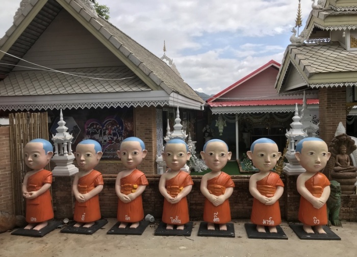 In einer Tempelanlage der thailändischen Grenzstadt Mae Sai stehen Steinfiguren, die die vor einem Jahr aus einer Höhle gerettete Jungen-Fußballmannschaft verkörpern sollen. Foto: Christoph Sator/dpa