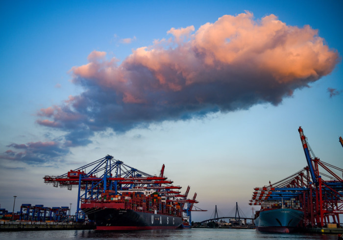 Hamburg: Containerschiffe werden im Hafen bei untergehender Sonne abgefertigt. Foto: dpa/Axel Heimken