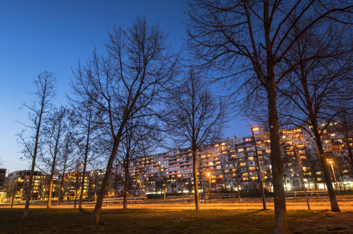 Gesamtansicht von Wohngebäuden mit beleuchteten Wohnungen bei Sonnenuntergang in Wien. Foto: epa/Christian Bruna