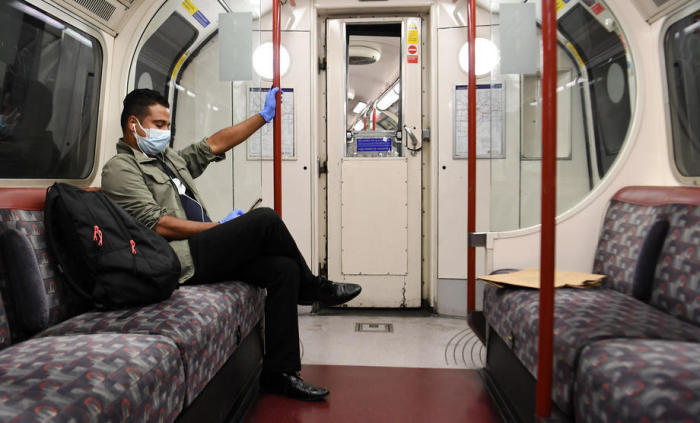 Ein Pendler trägt eine Gesichtsmaske, während er in der U-Bahn in London, Großbritannien, unterwegs ist. Archivfoto: epa/Andy Rain