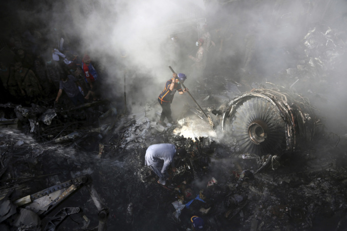 Freiwillige Helfer und Einsatzkräfte suchen nach Überlebenden, nachdem ein Flugzeug in einem Wohngebiet abgestürzt ist. Foto: Fareed Khan/AP/dpa