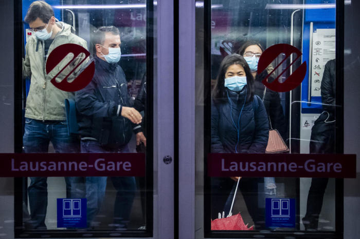 Pendler, die eine schützende Gesichtsmaske tragen, steigen in Lausanne Bahnhof CFF/SBB in die Métro Lausanne ein. Foto: epa/Jean-christophe Bott