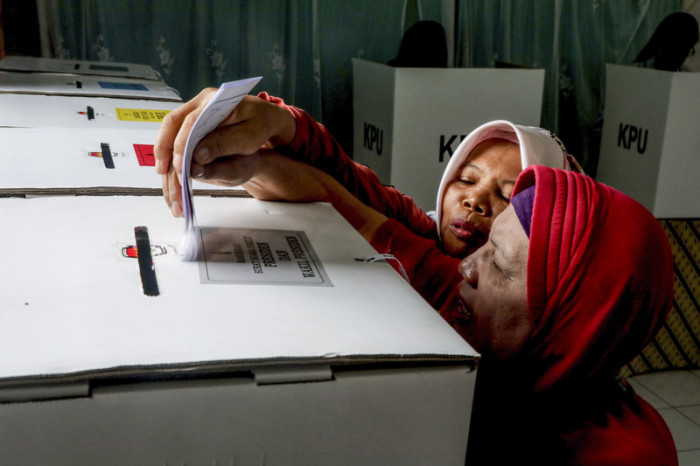 Zwei Frauen werfen ihre Stimmzettel in eine Wahlurne in Sumatra, Indonesien. Foto: epa/Dedi Sinuhaji