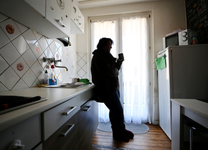 Eine Frau steht in Gelsenkirchen in ihrer Küche. Foto: Roland Weihrauch/Dpa