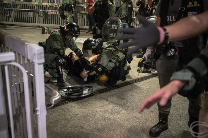 Sicherheitskräfte überwöltigen einen Demonstranten. Foto: epa/efe/Roman Pilipey