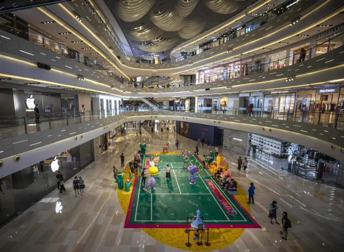 In Shanghai spazieren Besucher durch ein Einkaufszentrum mit Badmintonplatz. Foto: epa/Alex Plavevski