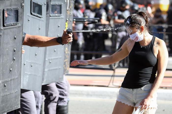 Während der Proteste des brasilianischen Präsidenten Jair Bolsonaro in Sao Paolo wird eine Person angesprayt. Foto: epa/Leo Barrilari