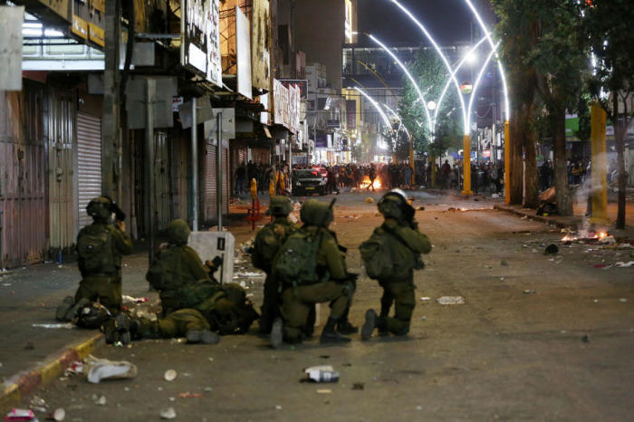 Israelische Truppen sind während Zusammenstößen mit palästinensischen Demonstranten im Stadtzentrum der Westbank-Stadt Hebron zu sehen. Foto: epa/Abed Al Hashlamoun