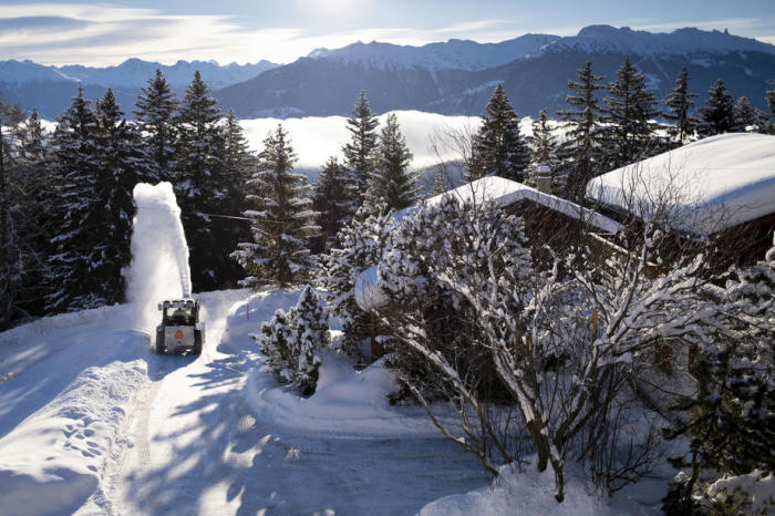 Ein Schneepflug räumt nach Schneefall in den Schweizer Alpen frischen Schnee von einer Straße. Foto: epa/Laurent Gillieron