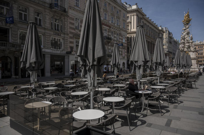 Menschen sitzen in einem Garten eines geschlossenen Restaurants an der Einkaufsstraße Graben in Wien. Foto: epa/Christian Bruna