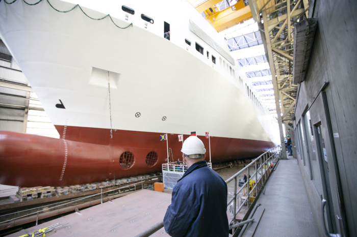 Ein Mitarbeiter beobachtet den Stapellauf des Ro-Ro-Schiffes «Leevsten» in der Werft der Flensburger Schiffbaugesellschaft (FSG). Foto: Frank Molter/Dpa