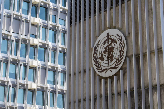 Das Logo und das Gebäude des Hauptsitzes der Weltgesundheitsorganisation (WHO) in Genf. Foto: epa/Martial Trezzini