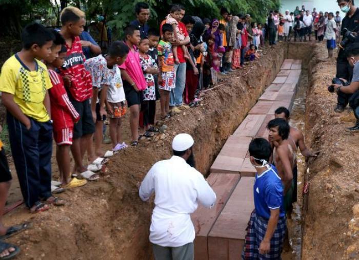 Schaulustige, darunter auch Kinder benachbarter Dörfer, beobachten die Bergung der 26 Leichen bei Pedang Basar. Mittlerweile werden bis zu 500 Opfer befürchtet.