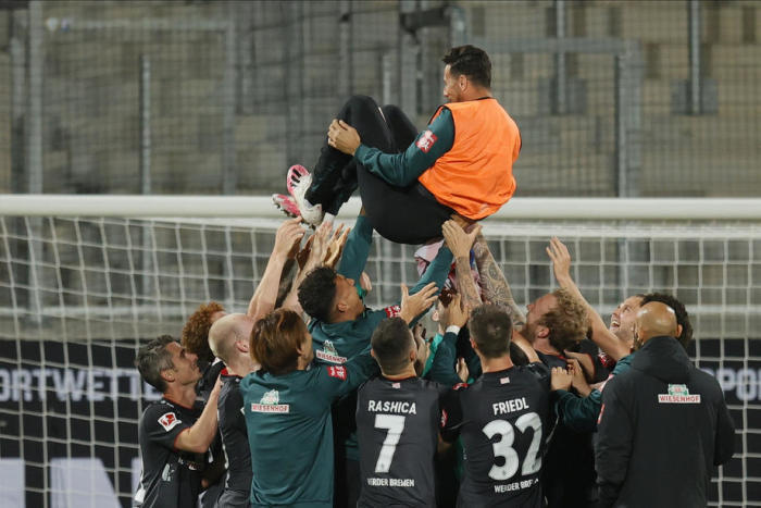 Die Spieler Bremens werfen den Bremer Claudio Pizarro in die Luft, während sie nach dem Abstiegsspiel der deutschen Bundesliga feiern. Foto: epa/Ronald Wittek