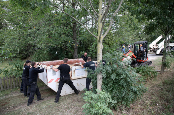 In Hannover graben Polizisten ein Gartengrundstück aus und durchsuchen es. Foto: epa/Friedemann Vogel