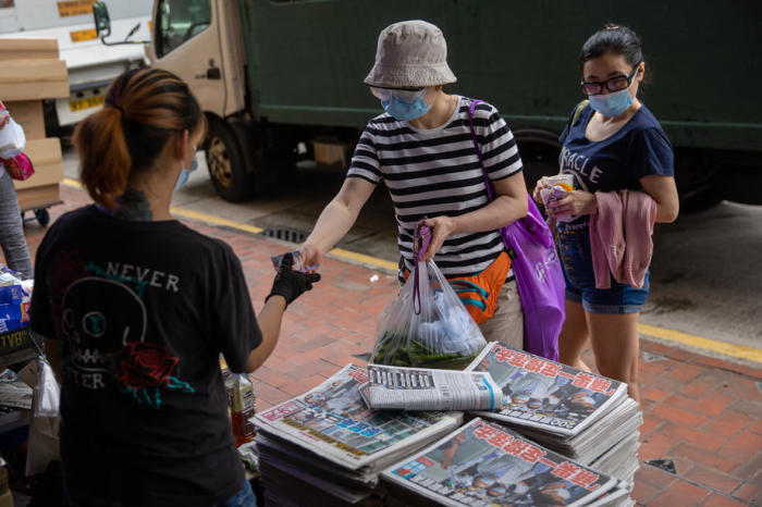 Jemand kauft ein Exemplar der Apple Daily an einem Zeitungsstand in Hongkong. Foto: epa/Jerome Favre