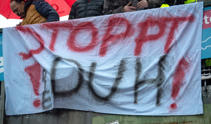 Ein Banner mit der Aufschrift «Stoppt DUH!» (Deutsche Umwelthilfe) hängt während einer Demonstration gegen das Dieselfahrverbot in Stuttgart an einer Brücke. Foto: Sebastian Gollnow/Dpa 